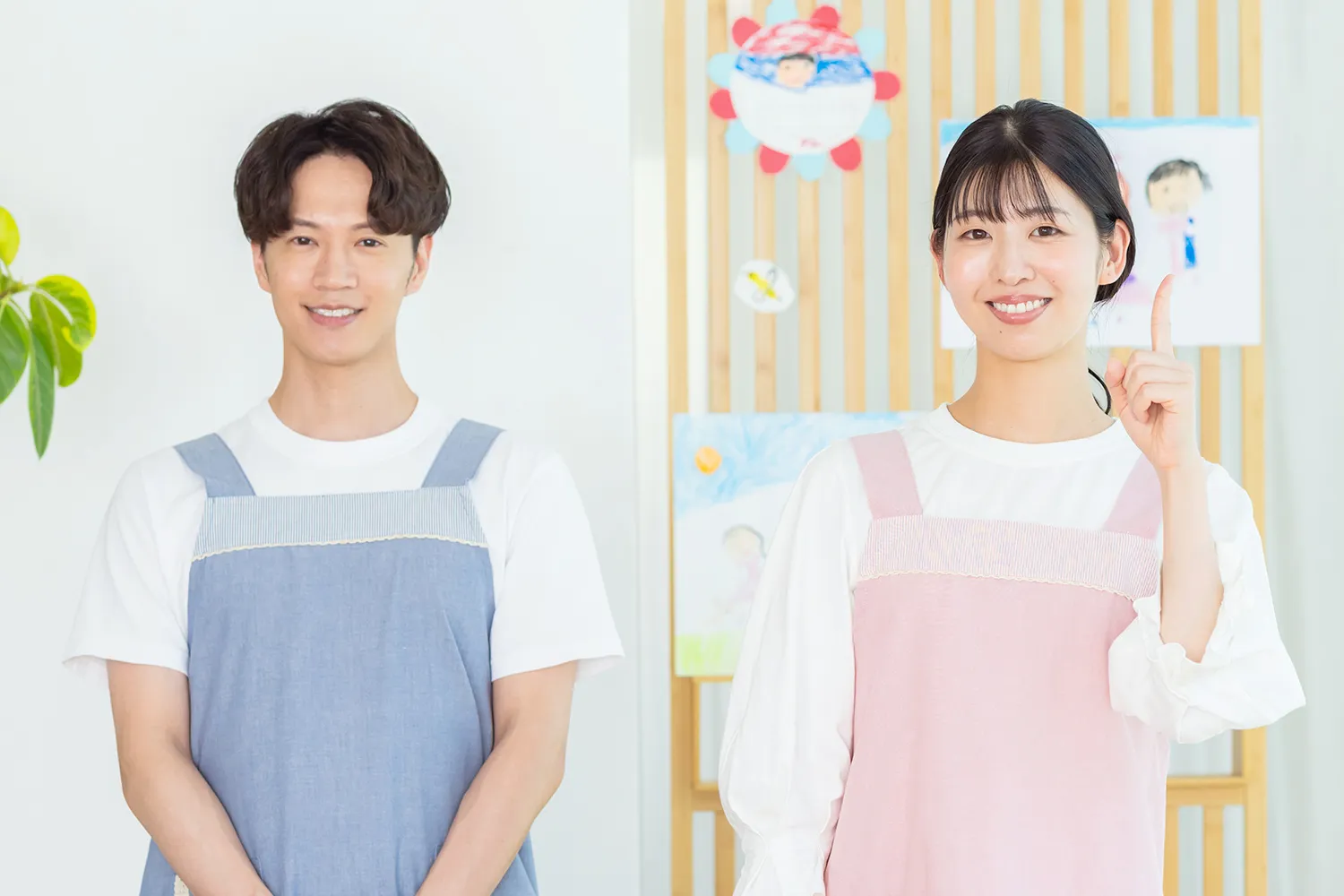 男性の保育士と指さす女性保育士の写真