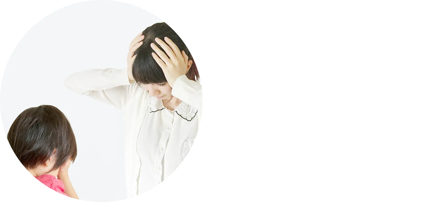 頭を抱える母親と泣いている子供の写真