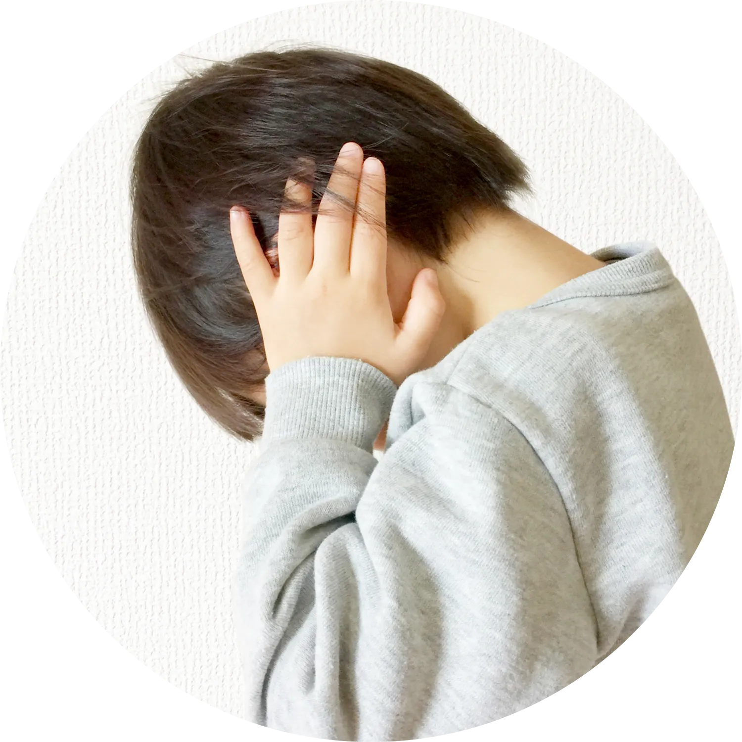 両手で耳を押さえる子供の写真