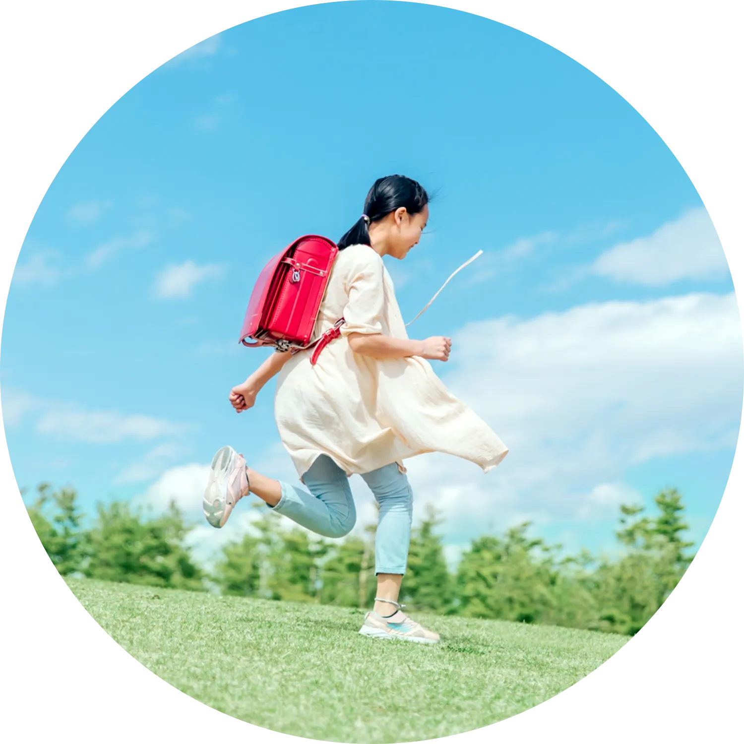 草原を走るランドセルの女の子の写真