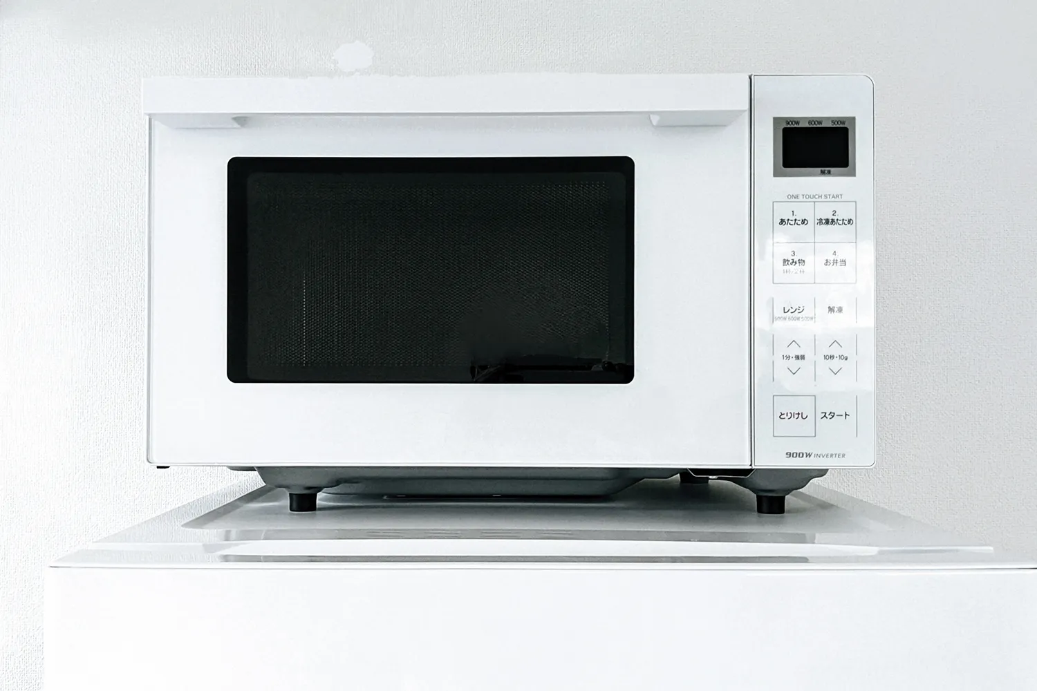 冷蔵庫の上にある電子レンジの写真