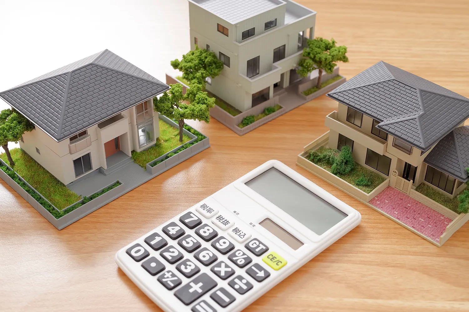 家の模型と電卓の写真