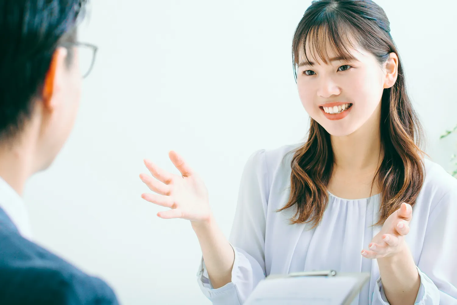 面接官に話をする若い女性の写真