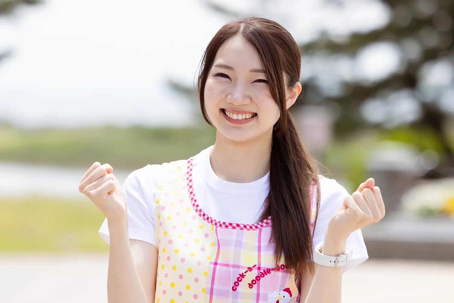  ガッツポーズのエプロンをつけた女性スタッフの写真